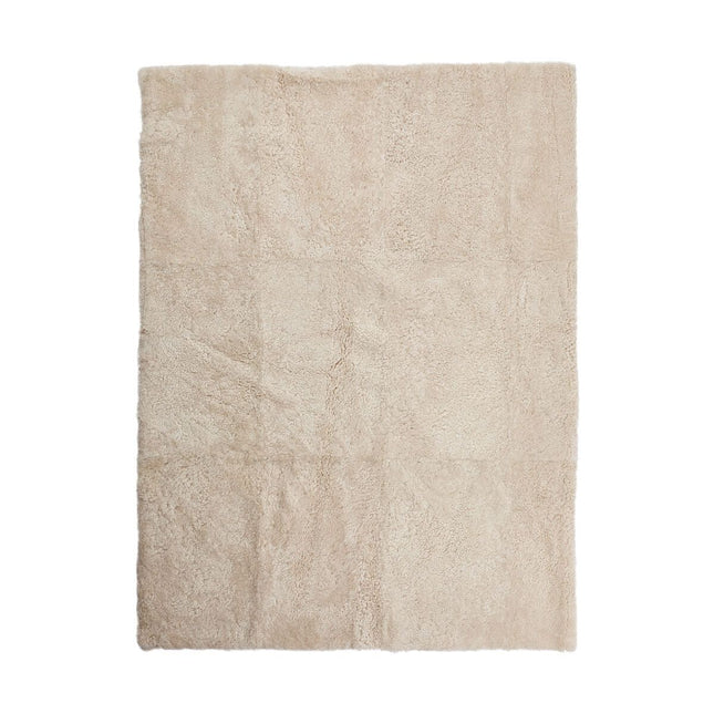 Kort ullteppe i krøllete saueskinn med design